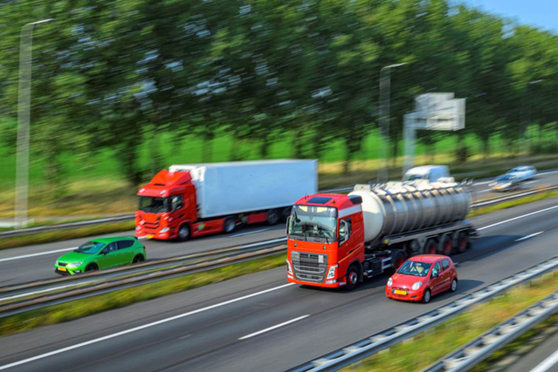 Trucks and cars travel down a highway.